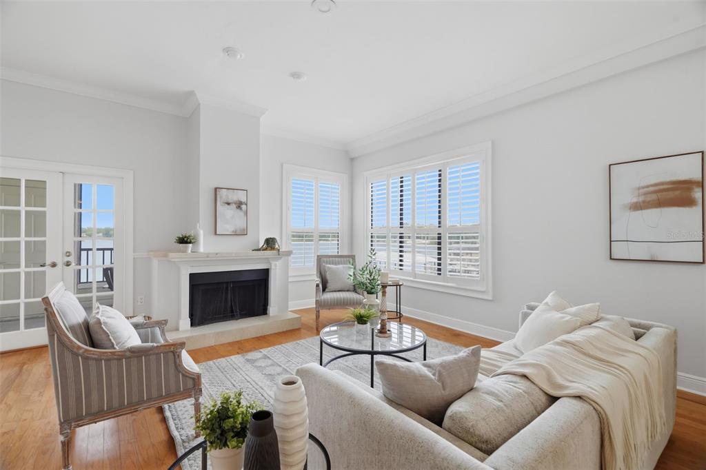 A living room features a fireplace, hardwood floors, a sofa, two armchairs, and large windows — 3127 W SLIGH AVENUE UNIT 203B, TAMPA, FL