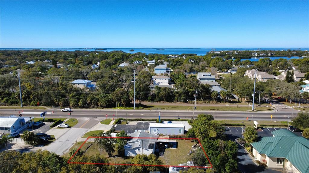 An aerial view shows a small house on a lot outlined in red near a road — 1007 MICHIGAN AVENUE, PALM HARBOR, FL