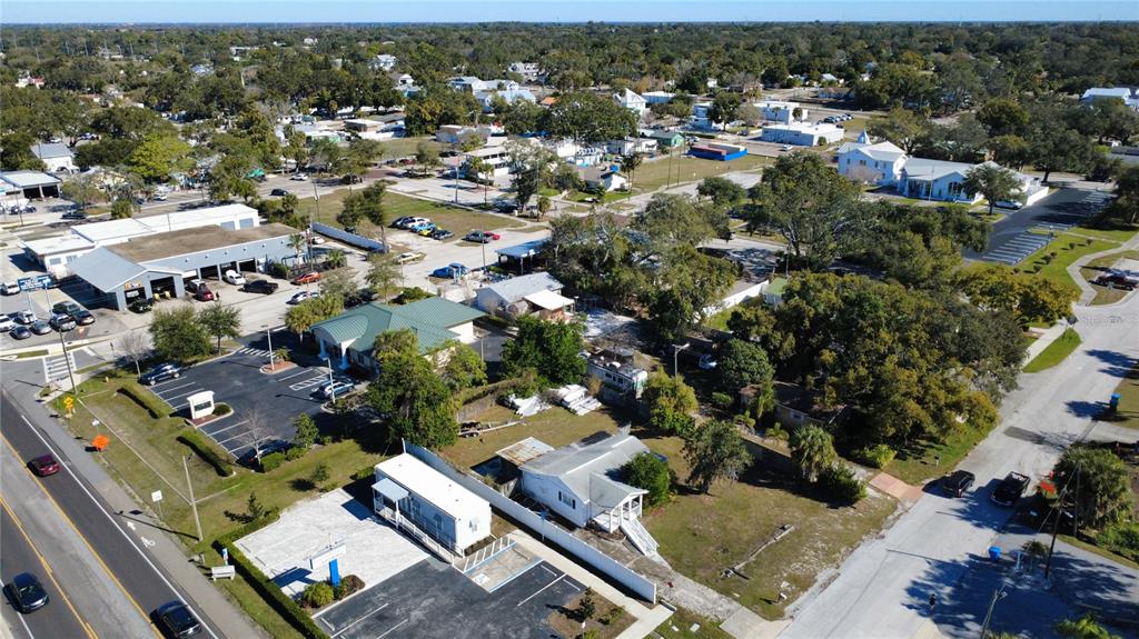 An aerial view shows a commercial building, a small house, and parking lots — 1007 MICHIGAN AVENUE, PALM HARBOR, FL