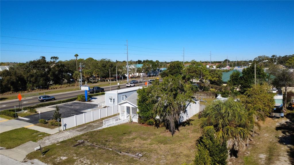 An aerial view shows a small building with a white fence next to a road — 1007 MICHIGAN AVENUE, PALM HARBOR, FL