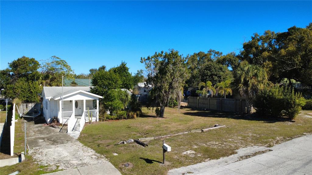 An aerial view shows a white house with a front porch and a large yard — 1007 MICHIGAN AVENUE, PALM HARBOR, FL