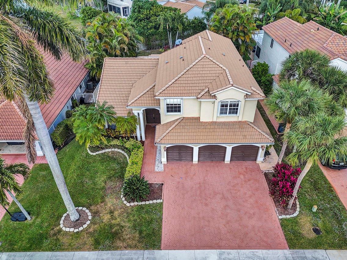 An aerial view of a two-story house with a tiled roof and a three-car garage — 19571 Black Olive Lane, Boca Raton FL 33498, BOCA RATON, FL