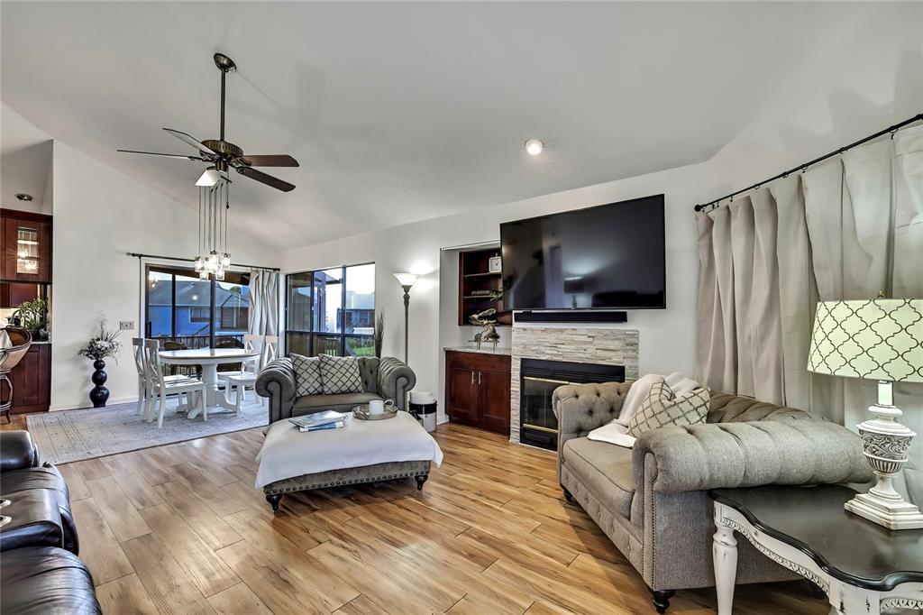 A living room features a stone fireplace with a mounted television and wood-look flooring — 2919 N RIVERS EDGE BOULEVARD UNIT 2919, CRYSTAL RIVER, FL