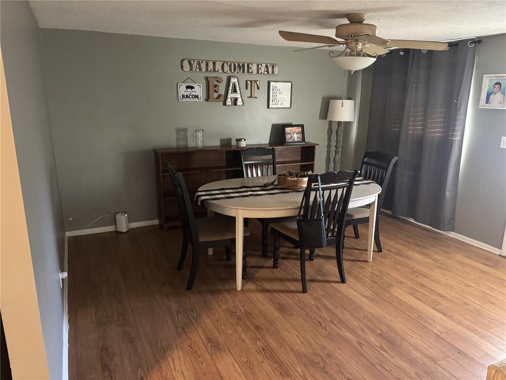 A dining room features a white oval table, four black chairs, and wall-mounted decor — 4801 AVON STREET, LAKE WALES, FL