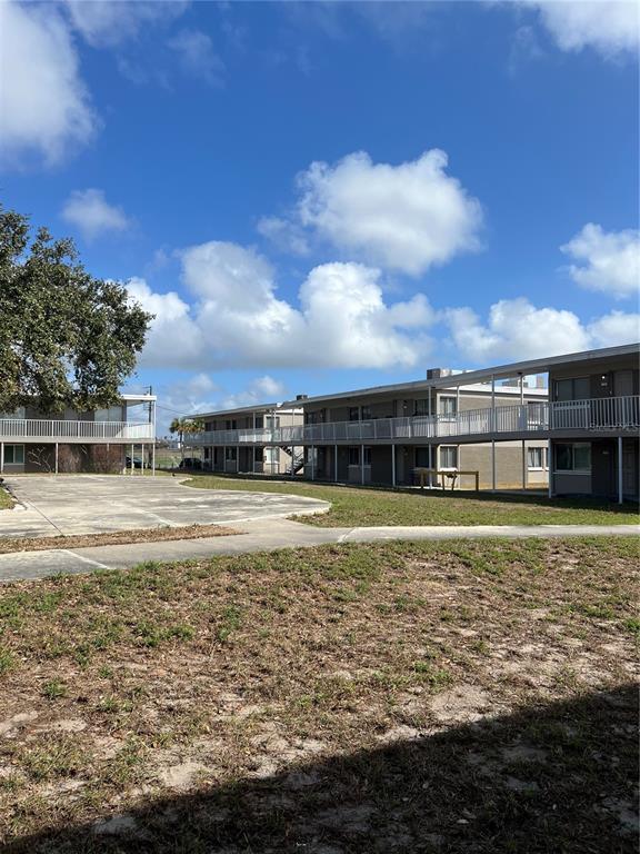 A two-story apartment building with exterior walkways and a concrete parking area — 800 N FISKE BOULEVARD UNIT 710, COCOA, FL