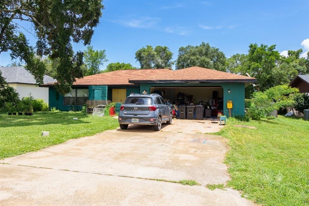 A single-story house with a green exterior, a two-car garage, and a concrete driveway — 15791 SW 46TH CIRCLE, OCALA, FL