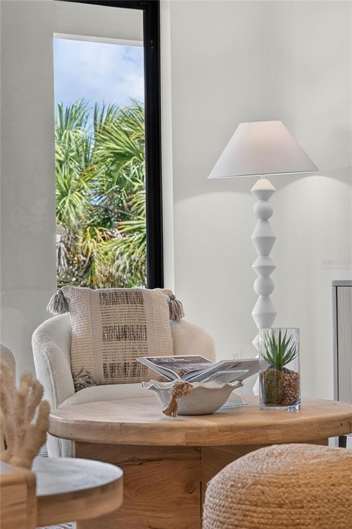 A modern living room features a round wooden coffee table, a textured armchair, and floor lamp — 9668 PRESIDENT CIRCLE, PORT CHARLOTTE, FL