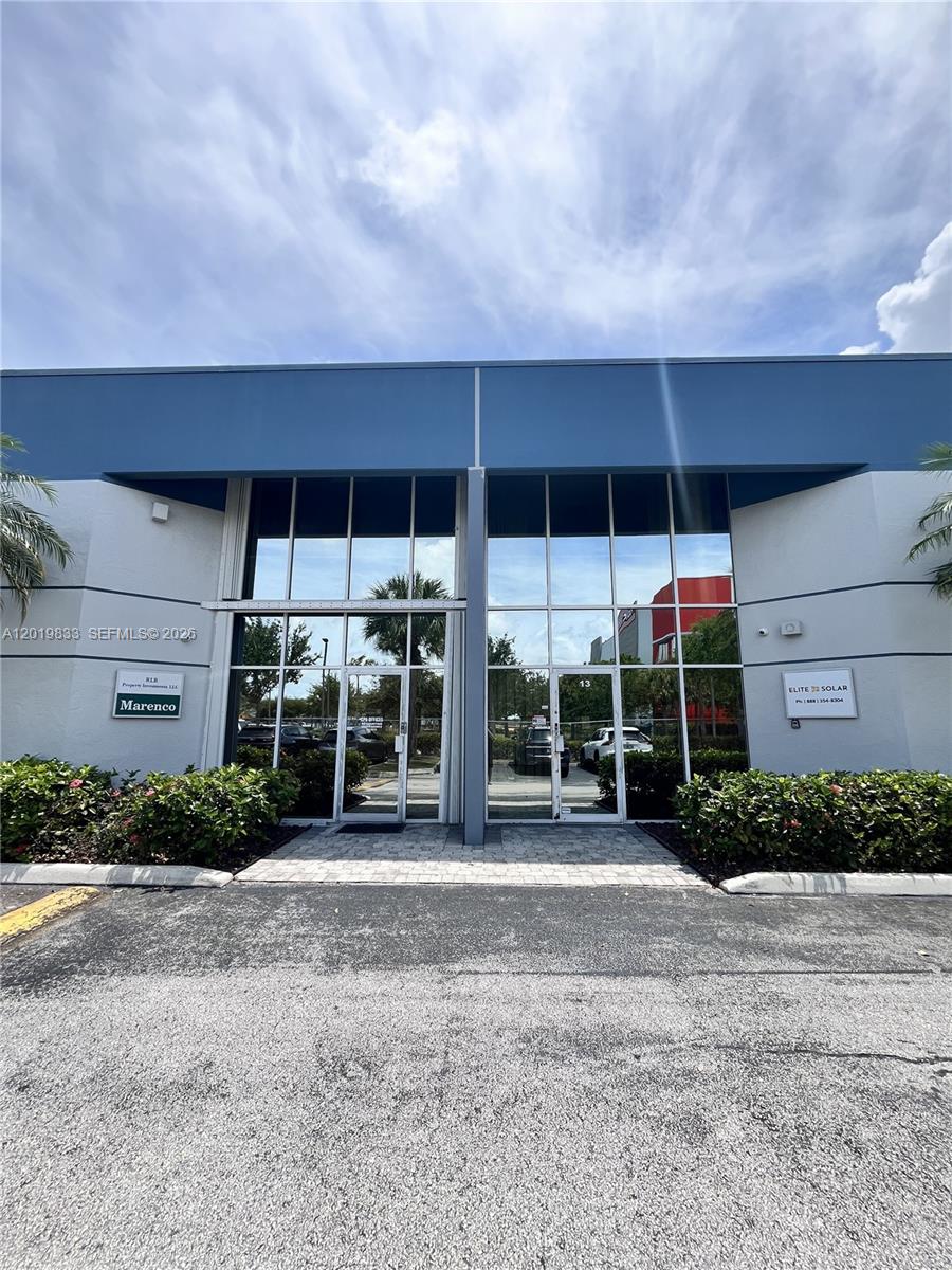 The exterior of a commercial building features glass storefront doors and signage for two businesses — 16115 SW 117th Ave # A13, Miami FL 33177, MIAMI, FL