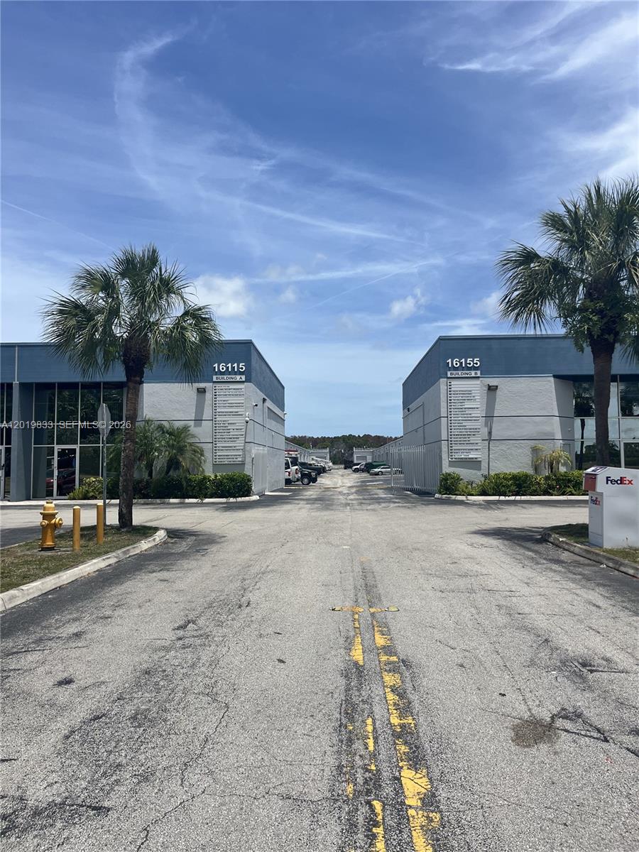 An exterior view shows two commercial buildings with palm trees and a paved driveway — 16115 SW 117th Ave # A13, Miami FL 33177, MIAMI, FL