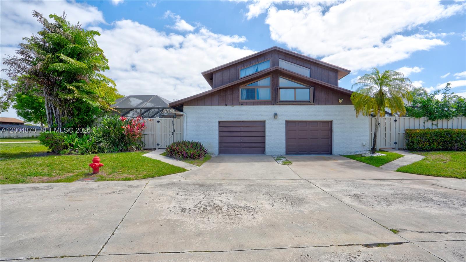 A two-story house with a white brick lower level, two garage doors, and brown siding — 9604 Boca Gardens Pkwy # A, Boca Raton FL 33496, BOCA RATON, FL