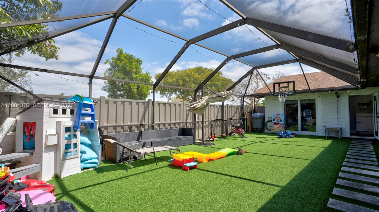 A screened-in patio features artificial turf, a children's playhouse, and a basketball hoop — 9604 Boca Gardens Pkwy # A, Boca Raton FL 33496, BOCA RATON, FL