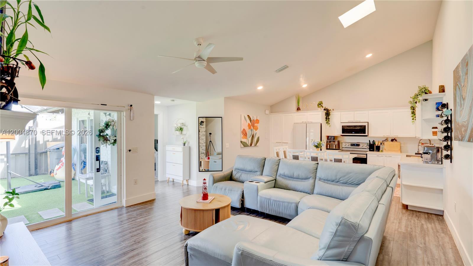 A living room with a sectional sofa, kitchen, and sliding glass doors to a patio — 9604 Boca Gardens Pkwy # A, Boca Raton FL 33496, BOCA RATON, FL