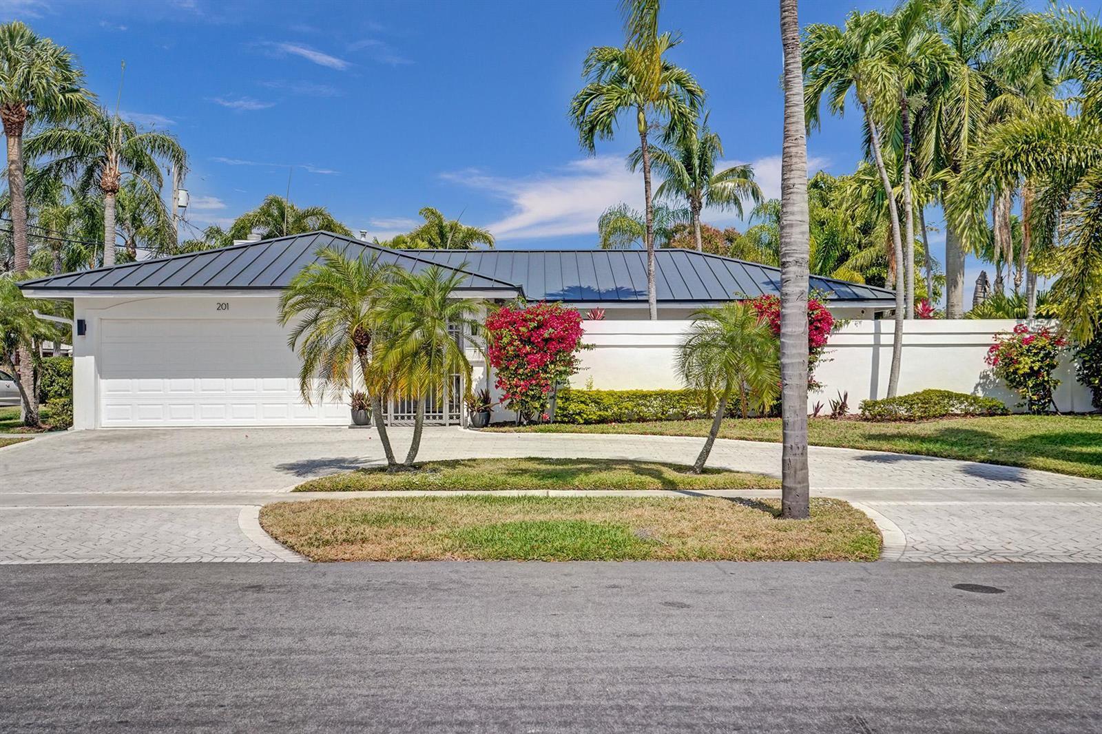 A single-story house with a metal roof, white walls, and palm trees in the front yard — 201 SE 11th Street, Pompano Beach FL 33060, POMPANO BEACH, FL