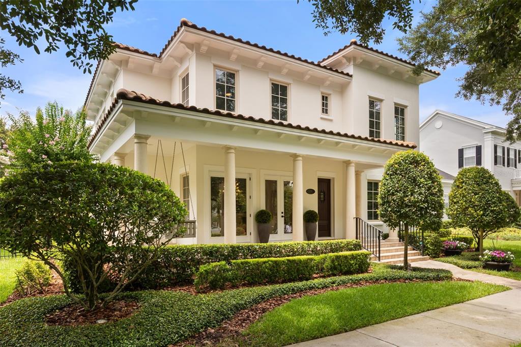 A two-story white house with a covered front porch, columns, and a tile roof — 2656 MEETING PLACE, ORLANDO, FL