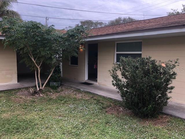 A beige exterior house with a concrete walkway, a front door, and two small trees — 7105 POINSETTA AVENUE UNIT 1, CAPE CANAVERAL, FL