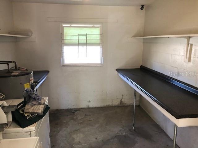 A utility room features a water heater, a long countertop, and a window — 7105 POINSETTA AVENUE UNIT 1, CAPE CANAVERAL, FL