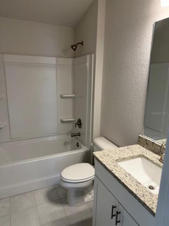 A bathroom features a white vanity with a granite countertop, a toilet, and a tub-shower — 2396 NW 23RD AVENUE, OCALA, FL