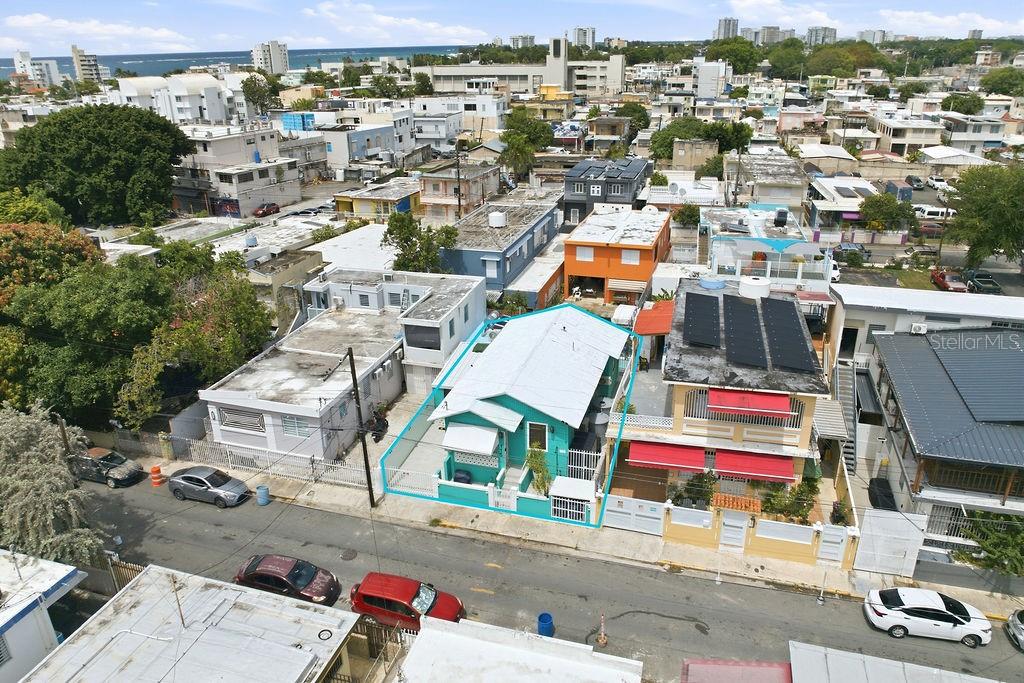 An aerial view shows a teal house with a white roof in a dense neighborhood — 115 SANTA CECILIA, SAN JUAN, PR