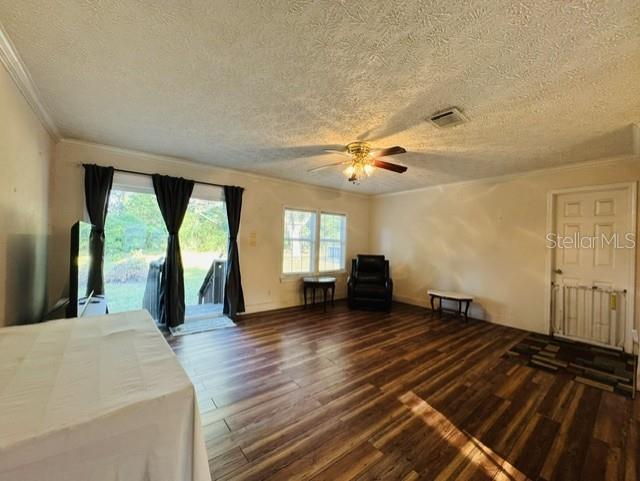 A living room features wood-look flooring, a ceiling fan, and a sliding glass door — 11817 SW 58TH STREET, WEBSTER, FL