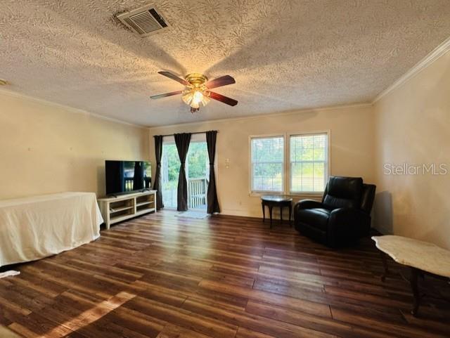 A living room features wood-look flooring, a ceiling fan, a television, and a recliner — 11817 SW 58TH STREET, WEBSTER, FL