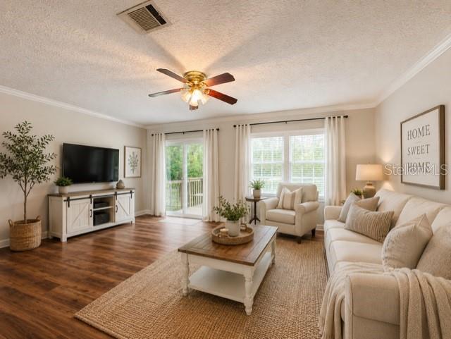 A living room features wood flooring, a ceiling fan, a television console, and a sofa — 11817 SW 58TH STREET, WEBSTER, FL