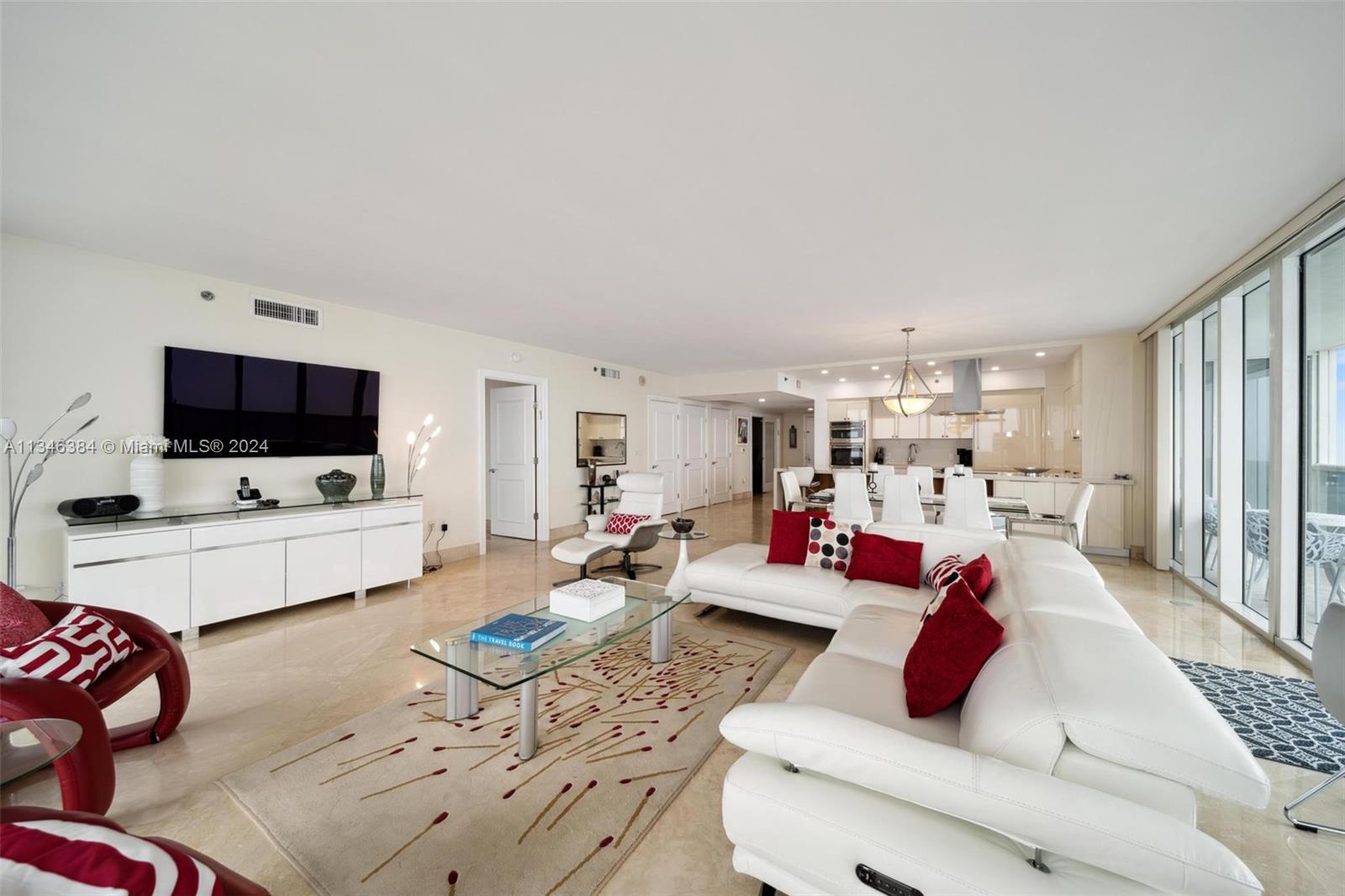A bright, open-concept living room features white leather furniture, a glass coffee table, and tile flooring — 1830 S Ocean Dr # 4602, Hallandale Beach FL 33009, HALLANDALE BEACH, FL