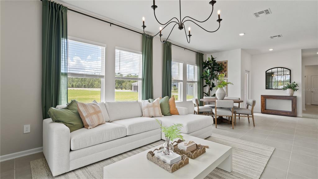A living room features a white sectional sofa, a coffee table, and a dining area — 4316 ST THOMAS WAY, KISSIMMEE, FL