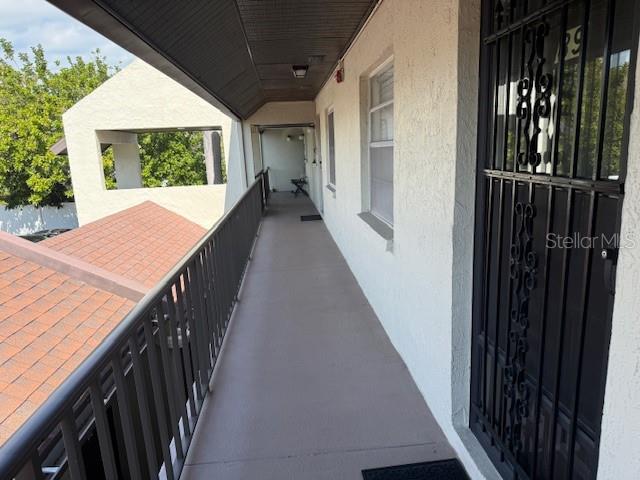 An outdoor walkway with a metal railing overlooks a shingled roof — 1100 EAST BAY DRIVE UNIT 89, LARGO, FL