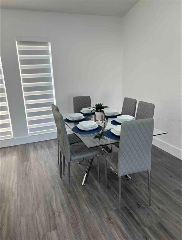 A dining room features a glass-topped table with six grey upholstered chairs on wood-look flooring — 3004 BANYAN WAY, PUNTA GORDA, FL