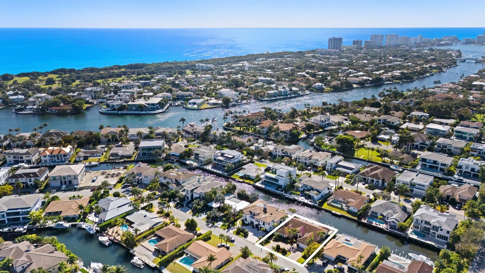 An aerial view shows a waterfront residential neighborhood with canals, swimming pools, and ocean views — 520 Phillips Drive, Boca Raton FL 33432, BOCA RATON, FL