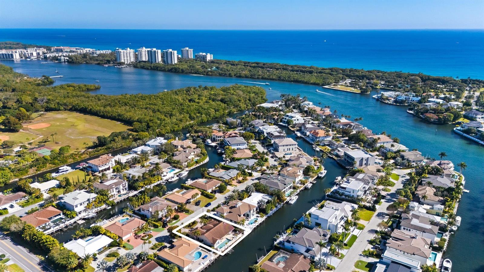 An aerial view shows a waterfront residential neighborhood with canals, swimming pools, and lush vegetation — 520 Phillips Drive, Boca Raton FL 33432, BOCA RATON, FL