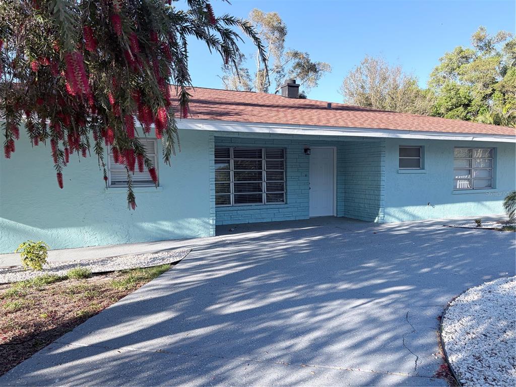 A light blue, single-story house with a brick facade and a concrete driveway — 1339 22ND STREET, SARASOTA, FL