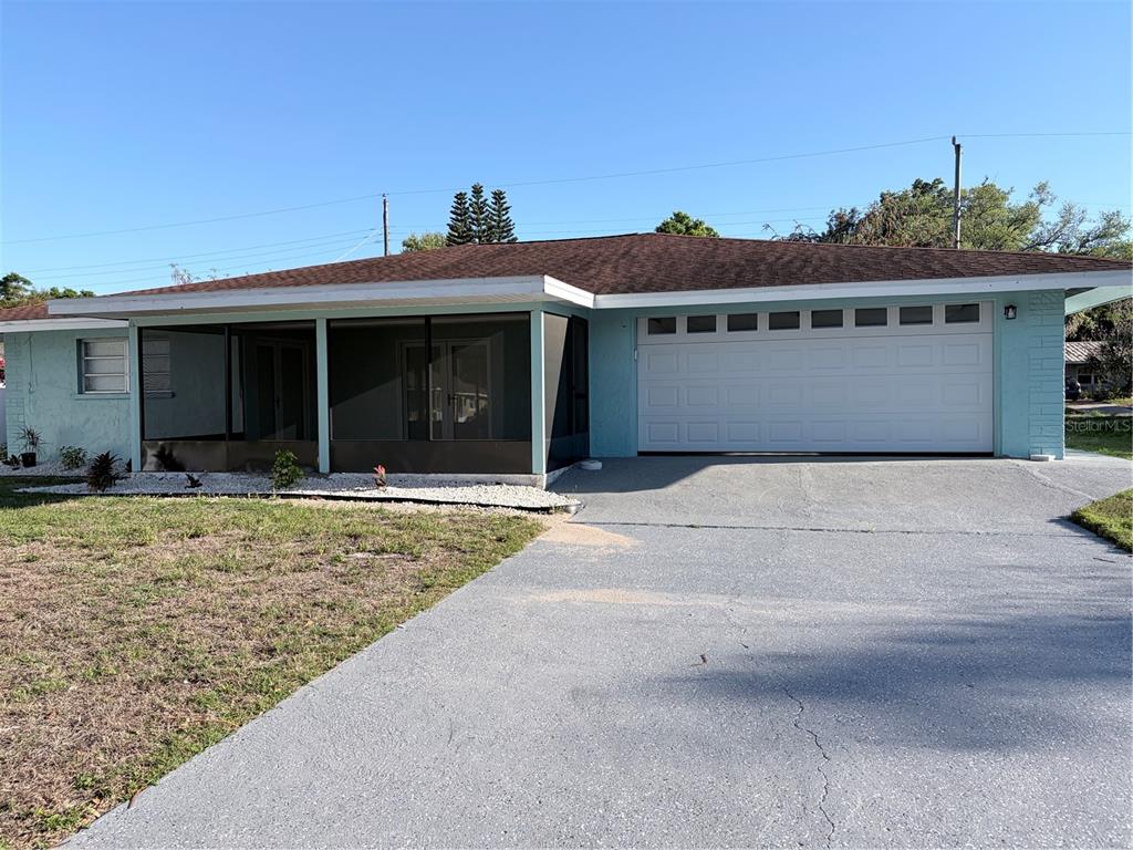 A single-story house with a light blue exterior, a screened-in porch, and a two-car garage — 1339 22ND STREET, SARASOTA, FL