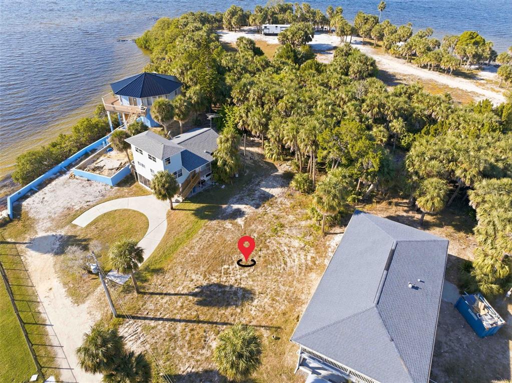 An aerial view shows several houses situated on a coastal lot with palm trees — 3461 CYCLONE DRIVE, WEEKI WACHEE, FL