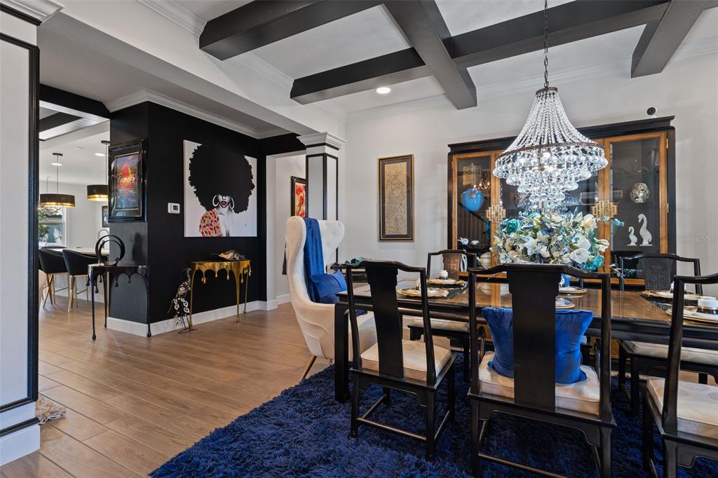A dining room features a coffered ceiling, a crystal chandelier, and a dark accent wall — 2534 CEDAR SHAKE COURT, OVIEDO, FL