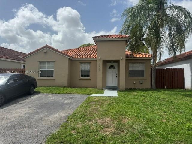 A single-story tan house with a red tile roof and a palm tree in front — 13073 SW 150th Ter, Miami FL 33186, MIAMI, FL