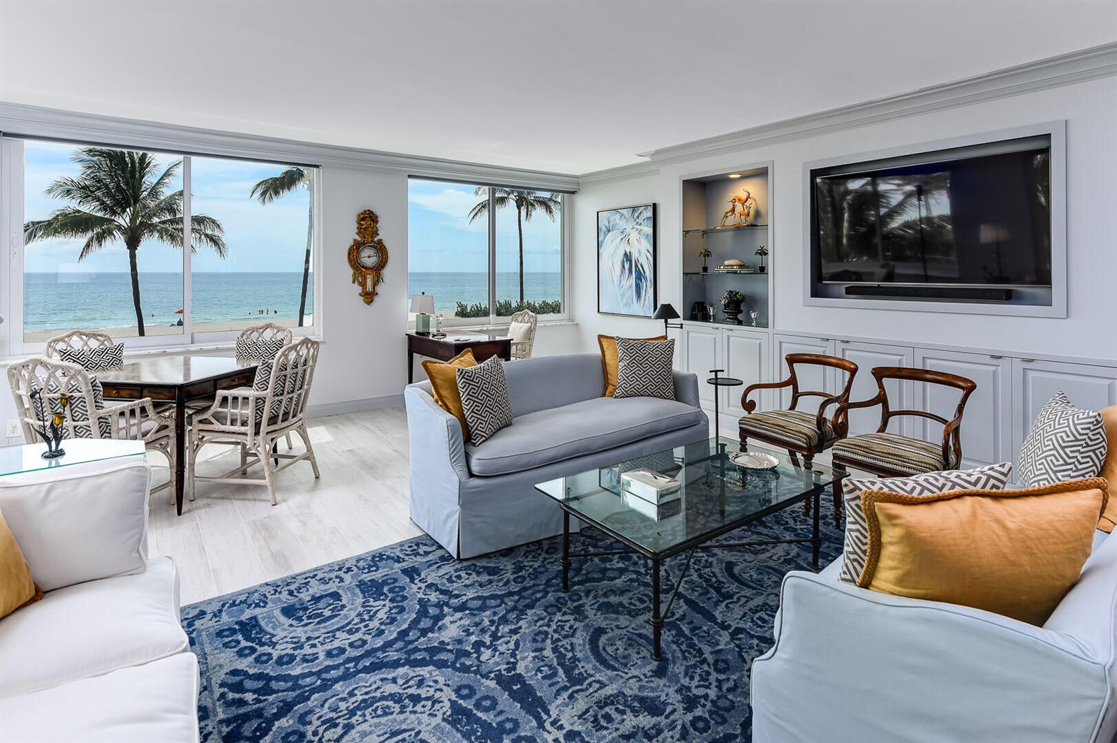 A living room with a blue rug, ocean views, and a large wall-mounted television — 340 S Ocean Boulevard # 2b, Palm Beach FL 33480, PALM BEACH, FL