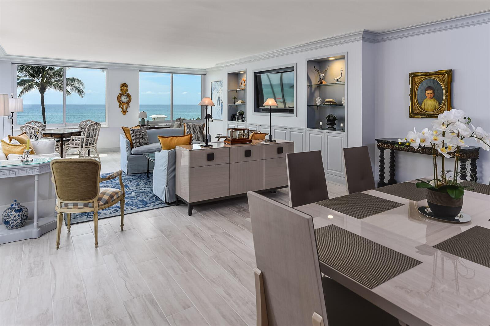 A bright, open-concept living and dining area features ocean views, light wood floors, and built-in shelving — 340 S Ocean Boulevard # 2b, Palm Beach FL 33480, PALM BEACH, FL