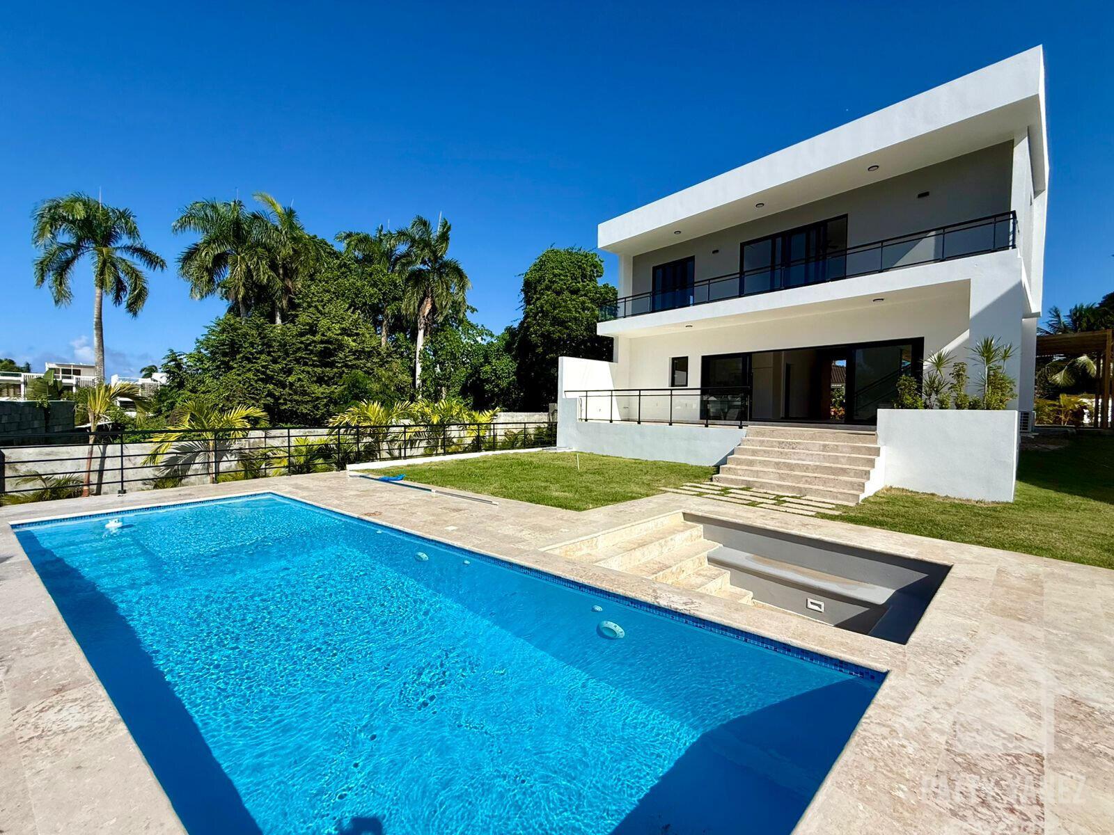 A modern two-story white house with a swimming pool, patio, and lawn under a blue sky — Perla Marina Residential Calle Perla, FL
