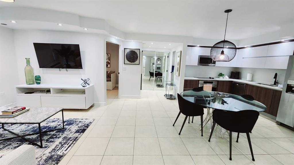 An open-concept living and dining area features white tile floors, modern cabinetry, and a television — Gallery Plaza DE DIEGO AVE. UNIT 1102-S, SAN JUAN, PR
