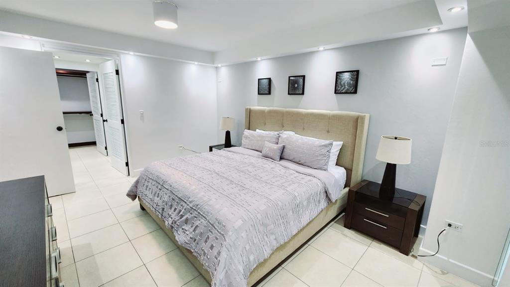 A bedroom features a beige upholstered headboard, a gray bedspread, and tile flooring — Gallery Plaza DE DIEGO AVE. UNIT 1102-S, SAN JUAN, PR