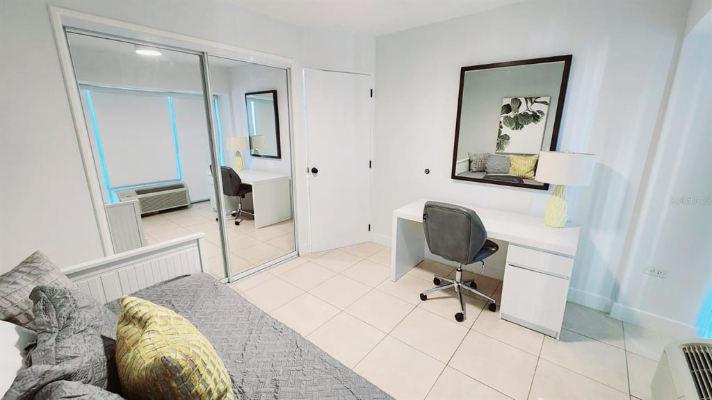 A bedroom features a desk, a bed, mirrored closet doors, and light-colored tile flooring — Gallery Plaza DE DIEGO AVE. UNIT 1102-S, SAN JUAN, PR