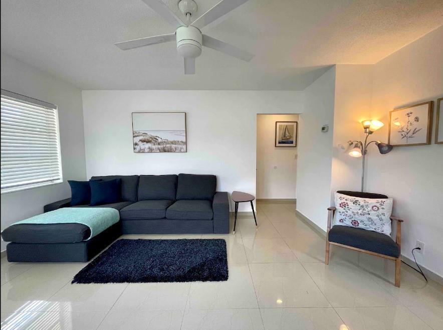 A living room features a dark gray sectional sofa, a matching rug, and a floor lamp — 29 NE 3rd Street # A, Dania Beach FL 33004, DANIA BEACH, FL