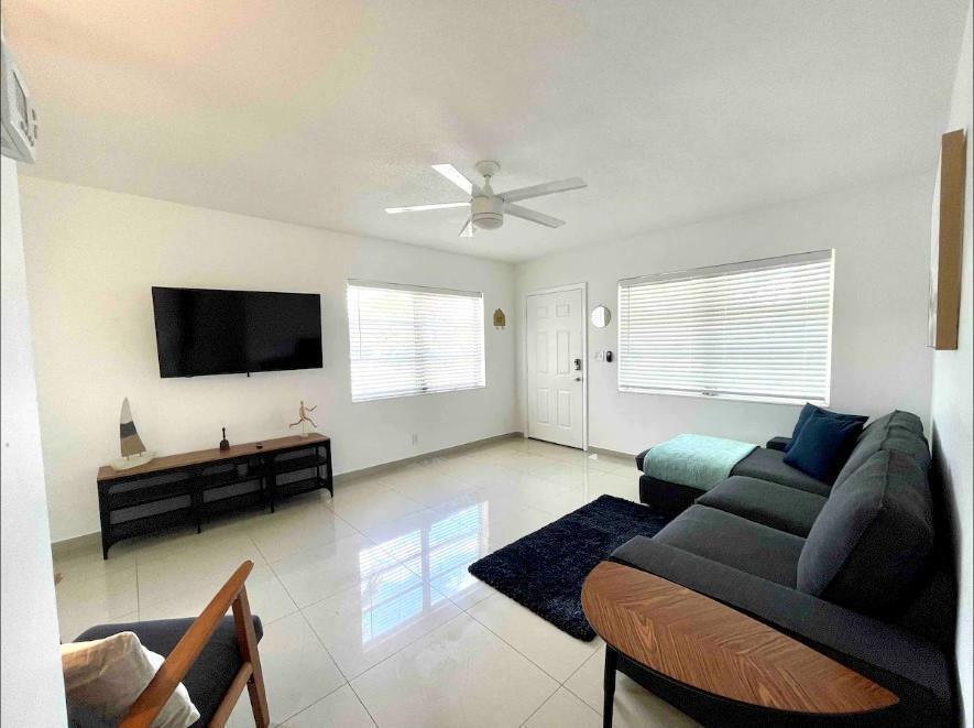 A living room features white walls, tile flooring, a ceiling fan, and a dark sectional sofa — 29 NE 3rd Street # A, Dania Beach FL 33004, DANIA BEACH, FL