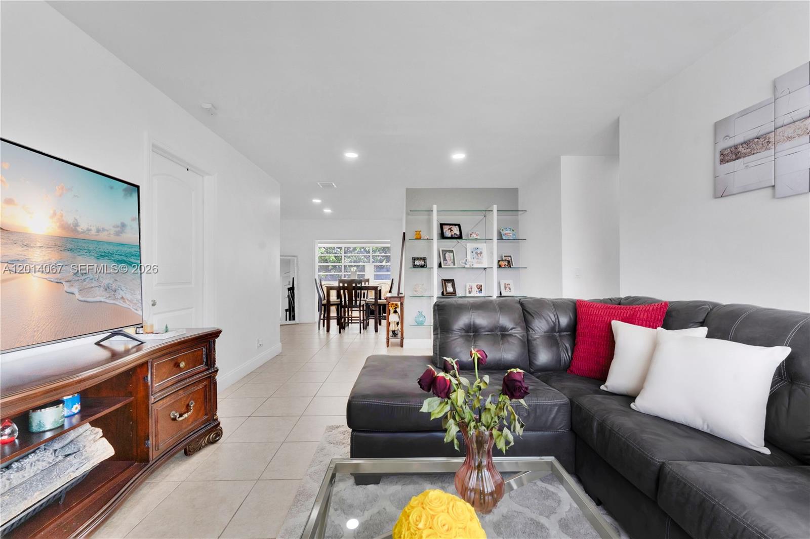 A living room features a dark leather sectional, a wooden media console, and tiled floors — 3171 NW 16th St, Lauderhill FL 33311, LAUDERHILL, FL