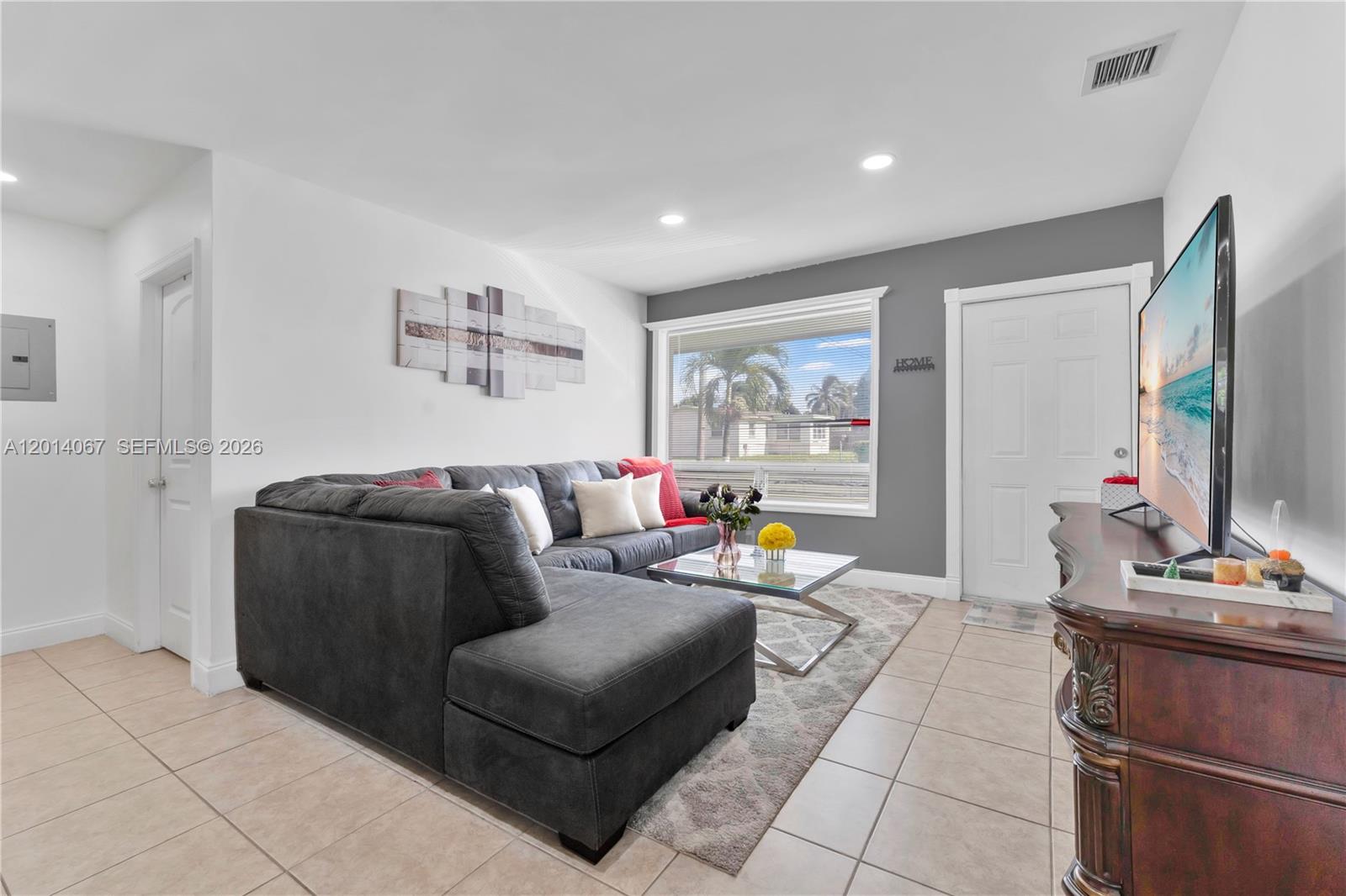 A living room features a grey sectional sofa, a glass coffee table, and tile flooring — 3171 NW 16th St, Lauderhill FL 33311, LAUDERHILL, FL