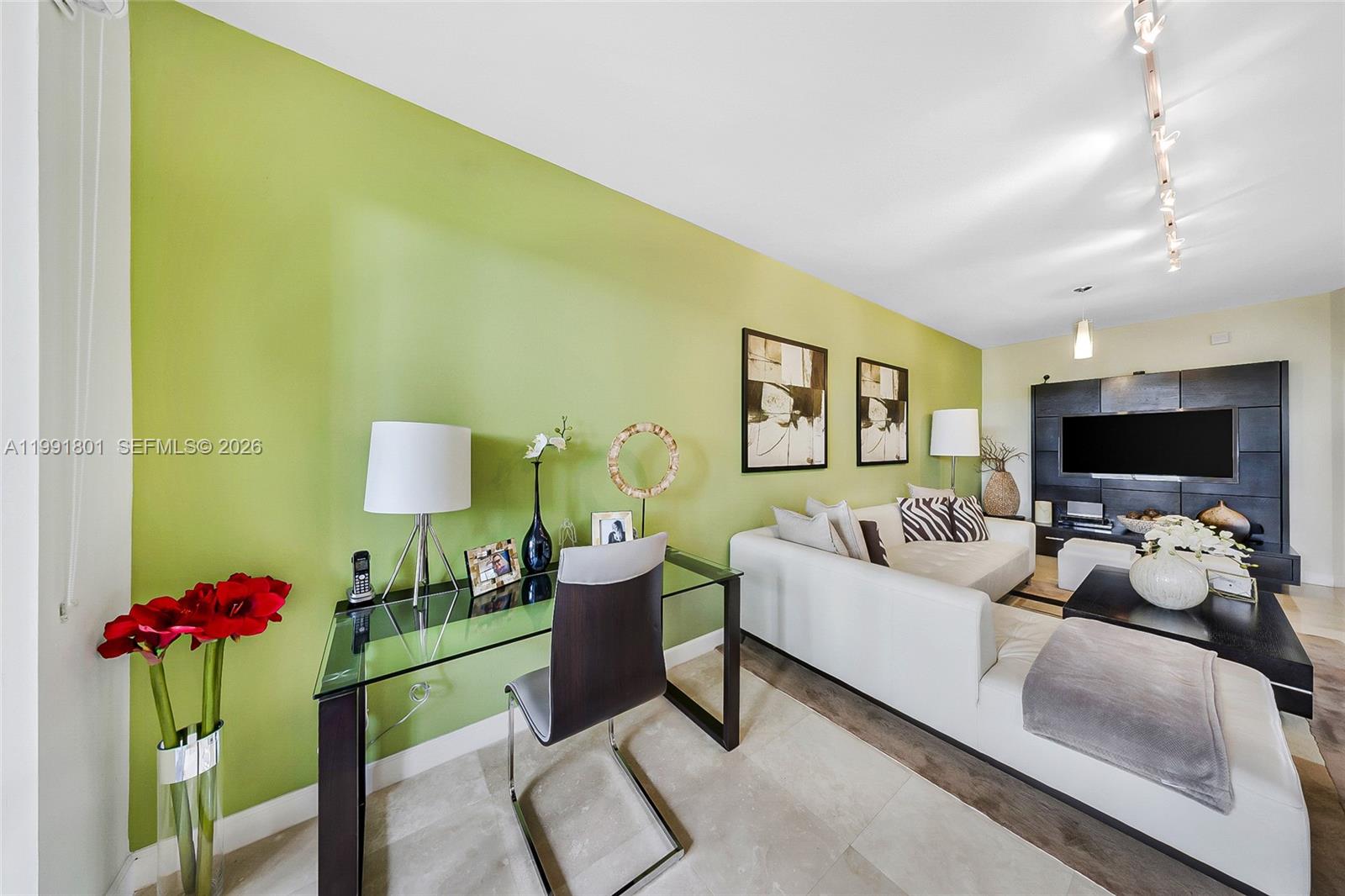 A living room features a green accent wall, a glass desk, and a white sofa — 10711 NW 75th Ln, Doral FL 33178, DORAL, FL