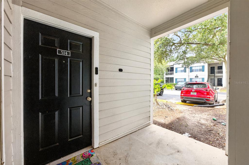 A black front door with the number 514 opens onto a covered concrete entryway — 5118 CITY STREET UNIT 514, ORLANDO, FL