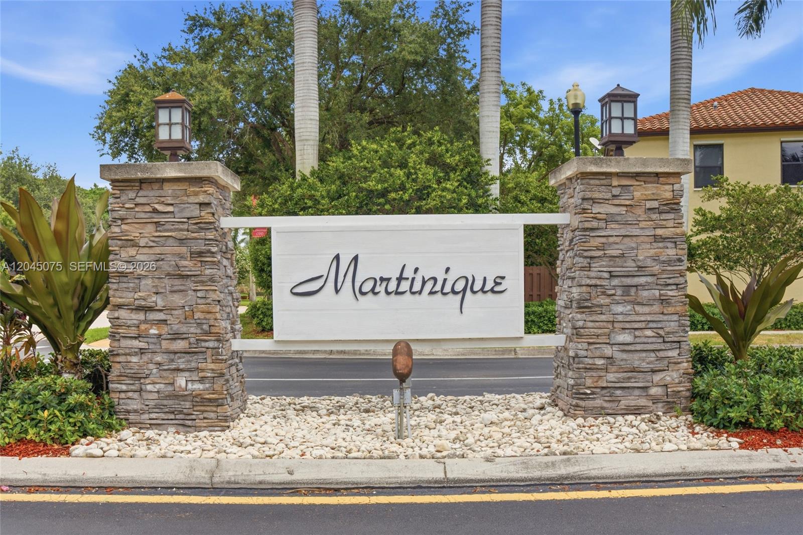 A stone-pillared entrance sign for a community named Martinique stands beside a paved road — 540 SE 32nd Ave, Homestead FL 33033, HOMESTEAD, FL