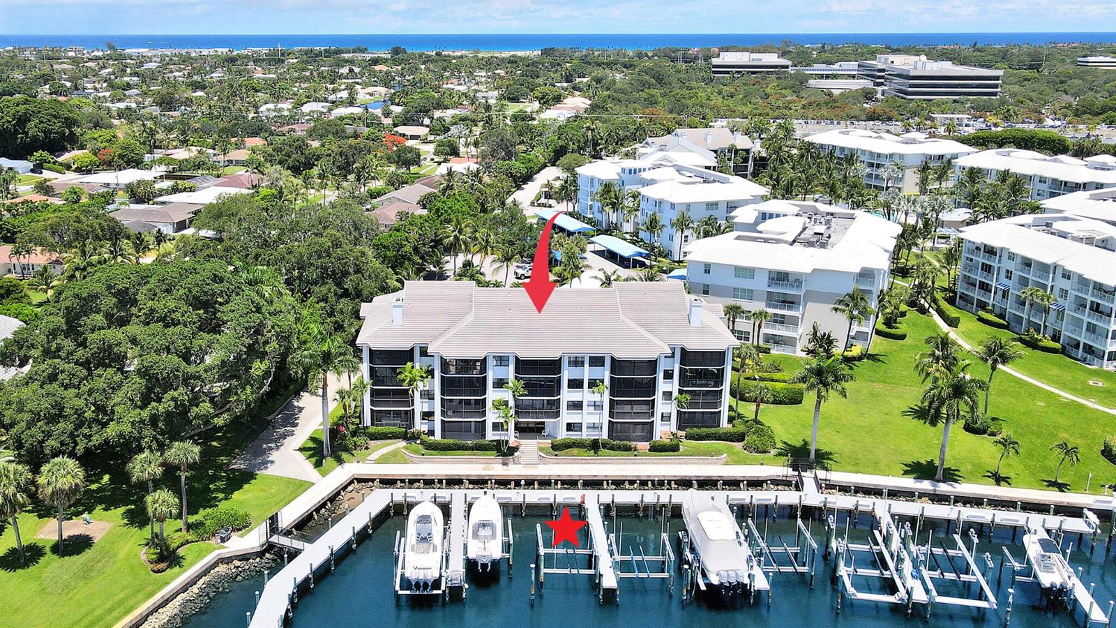 An aerial view of a multi-story waterfront condominium building with a private boat dock — 543 Bay Colony Drive N Slip 8, Juno Beach FL 33408, JUNO BEACH, FL